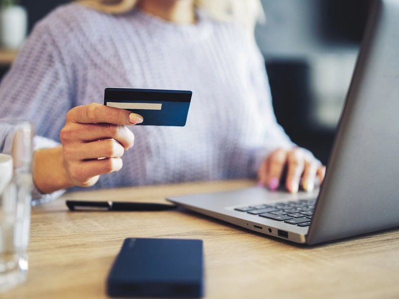 women with a card in front a laptop - bobbiejoes